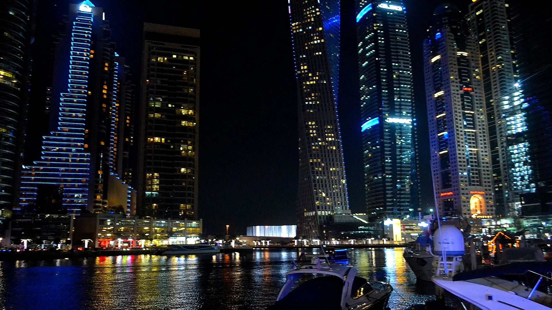 Dubai Marina's illuminated tower hotels and the marina promenade at night